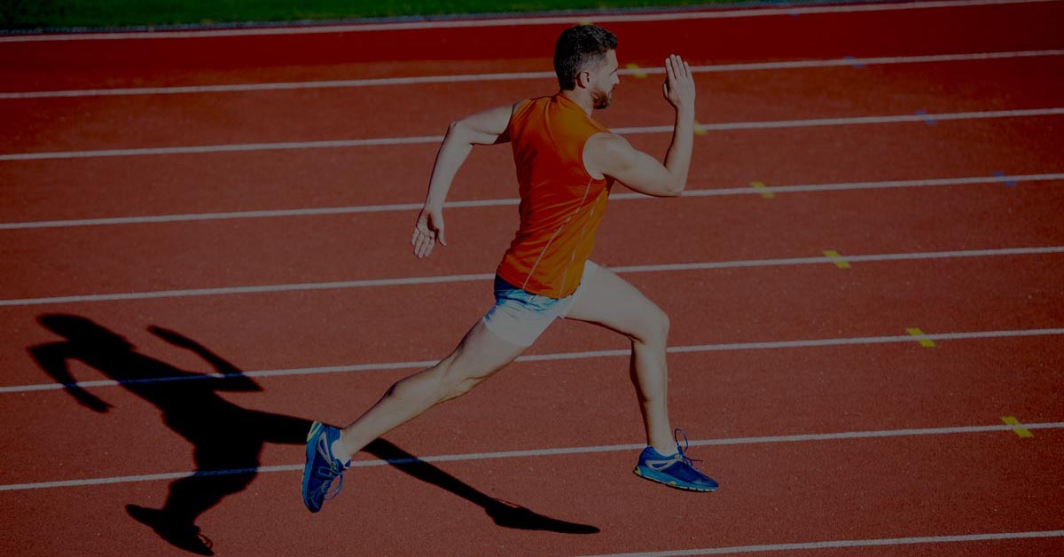 Male sprinter approaching the finish line, representing speed and efficiency in automated bank reconciliation.