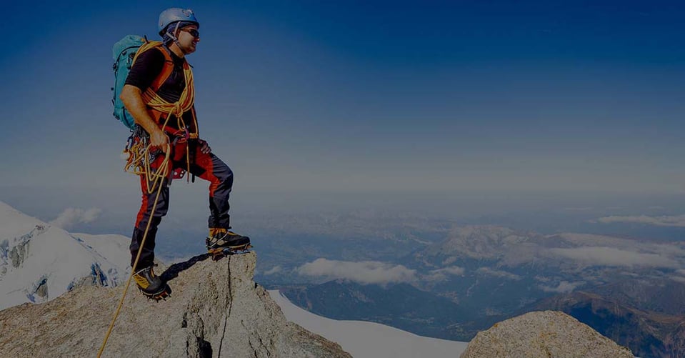 Mountain climber overlooking a landscape representing family office governance, oversight, transparency, and long-term financial planning