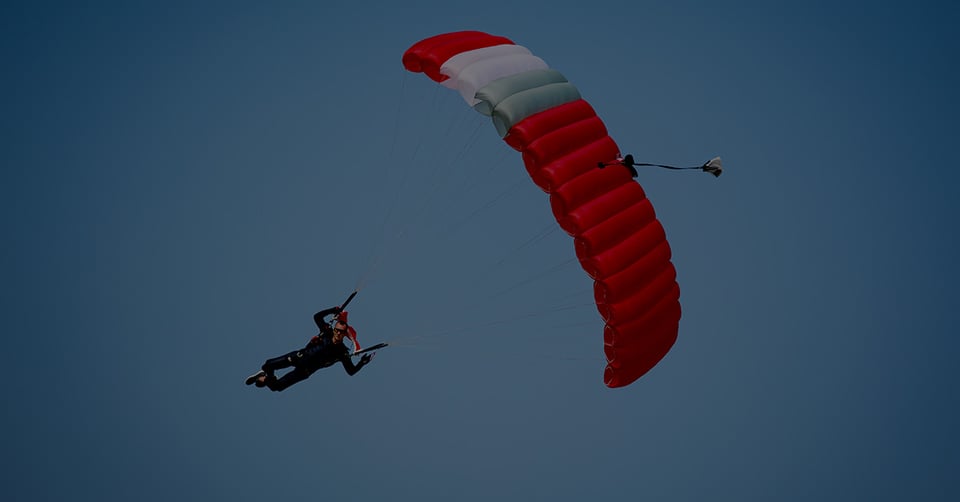 Man parachuting through the sky, symbolizing CFOs taking a calculated leap into AI-powered accounting—balancing risk, strategy, and control to land smoothly in a more efficient, automated future.