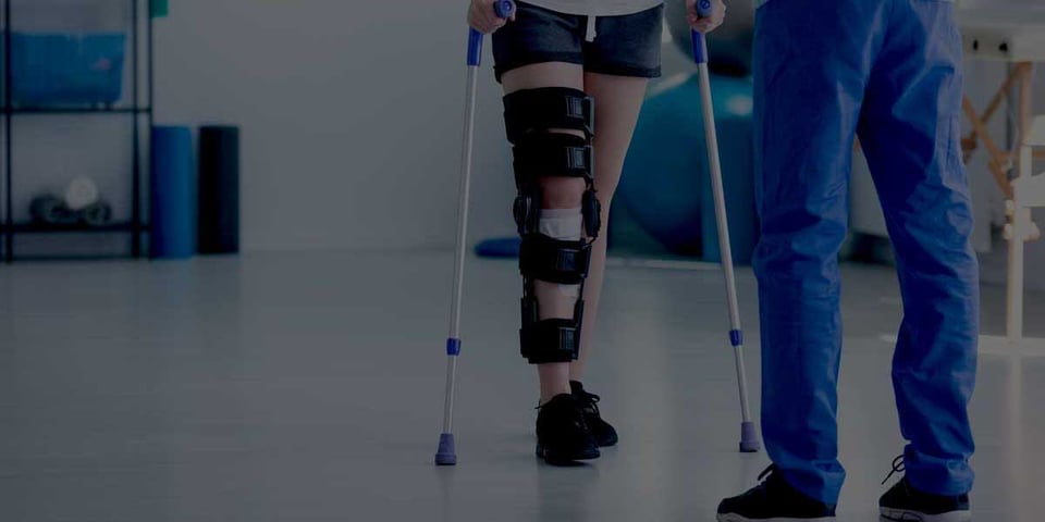 Healthcare professional assisting a patient during rehabilitation, representing financial integration and organizational transition during healthcare consolidations