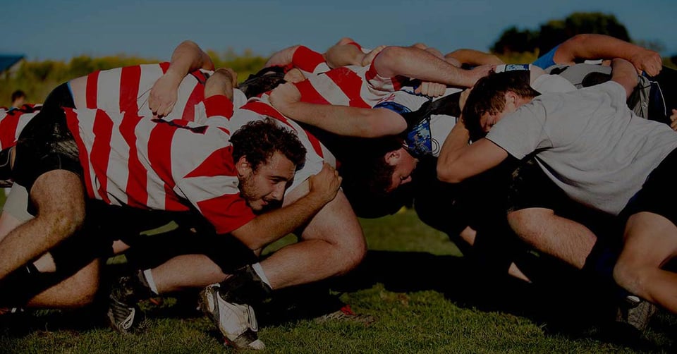Rugby players working together in a scrum, representing teamwork, coordination, and managing multiple companies efficiently.