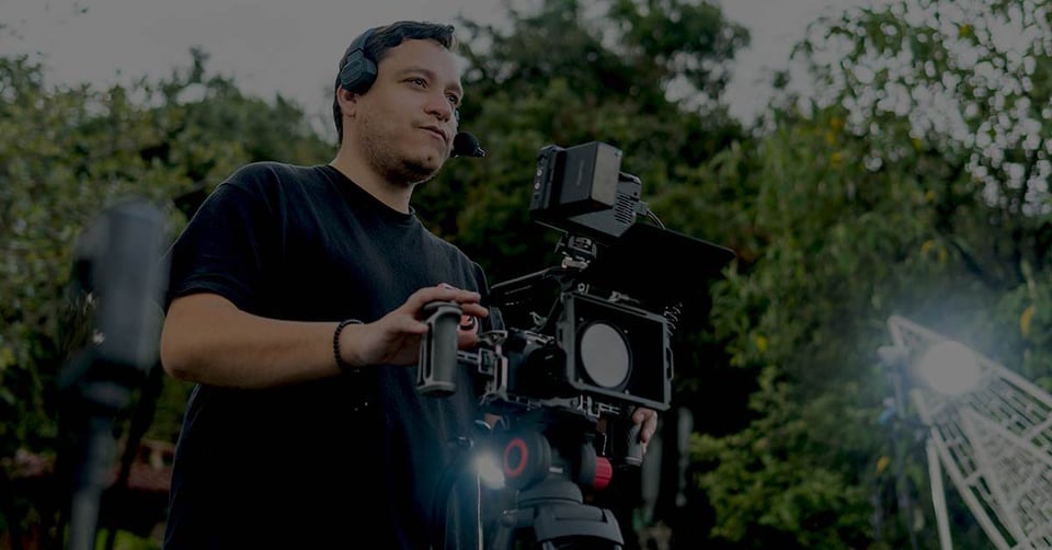 Camera operator filming a media production with professional video equipment.