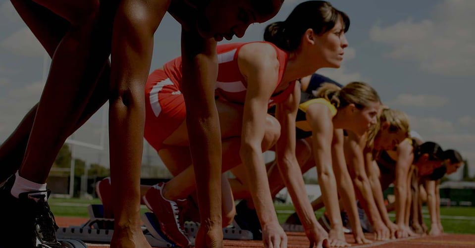 Track athletes at the starting line representing growing businesses preparing for the next stage after outgrowing QuickBooks Online