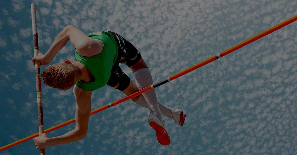 Athlete clearing the high jump bar, representing growing businesses moving beyond QuickBooks Desktop to a scalable cloud accounting solution.