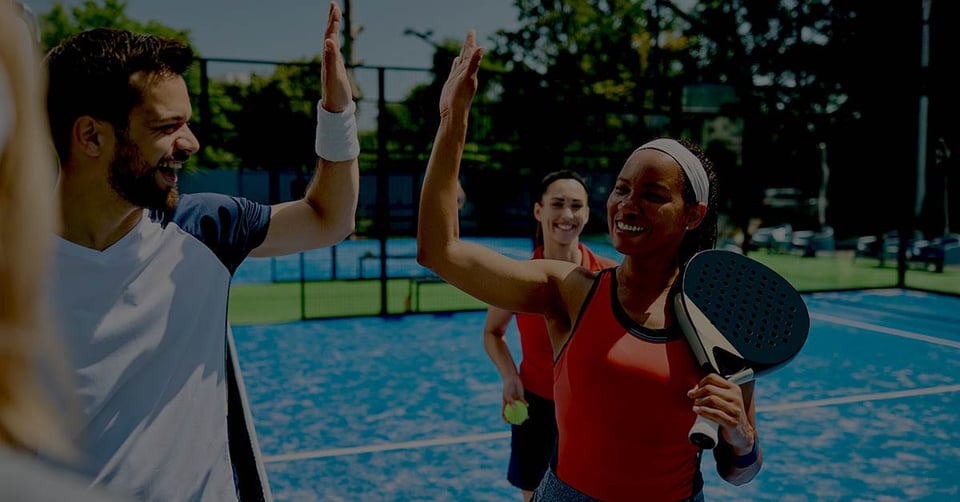 Pickleball players high-fiving to represent teamwork in modern invoice approval workflows with Gravity Software